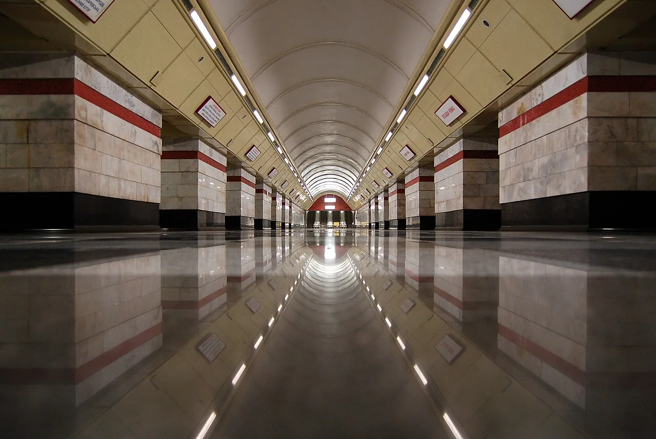 Центральний зал станції метро «Сирець» із рядами колон і підсвіченим склепінням