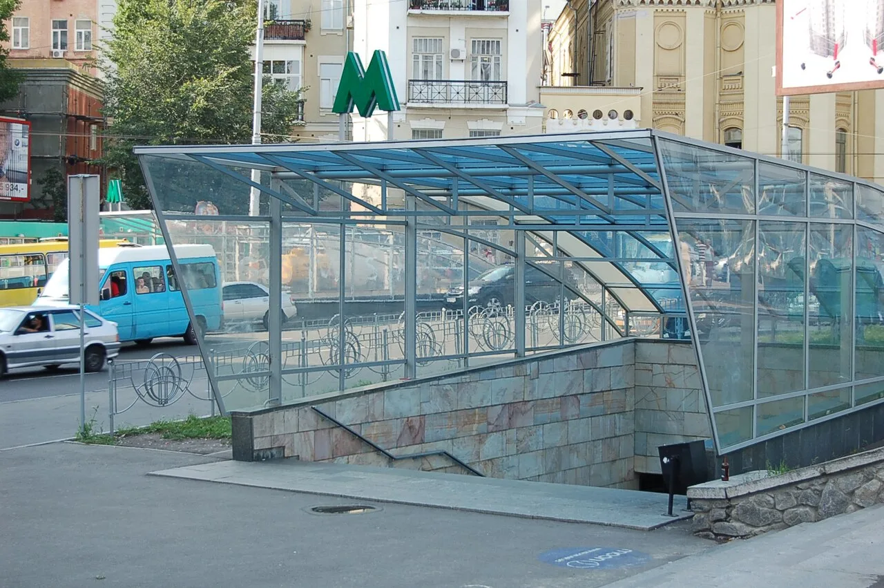 Зовнішній вхід до станції метро «Палац спорту» зі скляним накриттям. Зовнішній вхід до станції метро «Палац спорту» зі скляним накриттям.