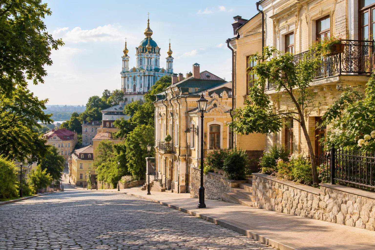 Брукована вулиця Києва зі старовинними будинками та Андріївською церквою на пагорбі