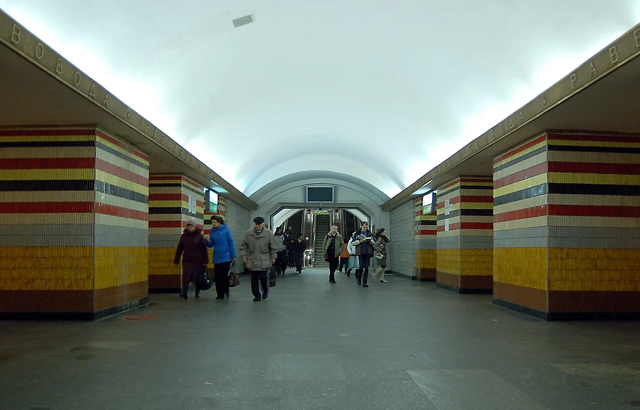 Центральний зал станції метро «Шулявська» у Києві, люди біля переходу.